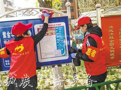 市第十一小学志愿者在擦拭宣传栏。 本报记者 张甜歌 摄